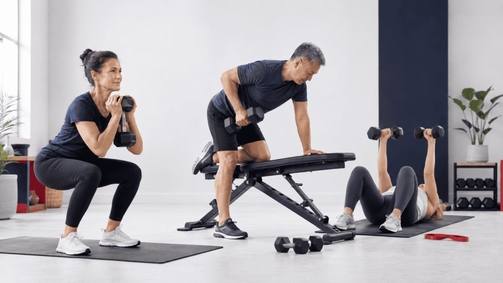 Beginners performing controlled full-body strength exercises with dumbbells in an accessible training environment